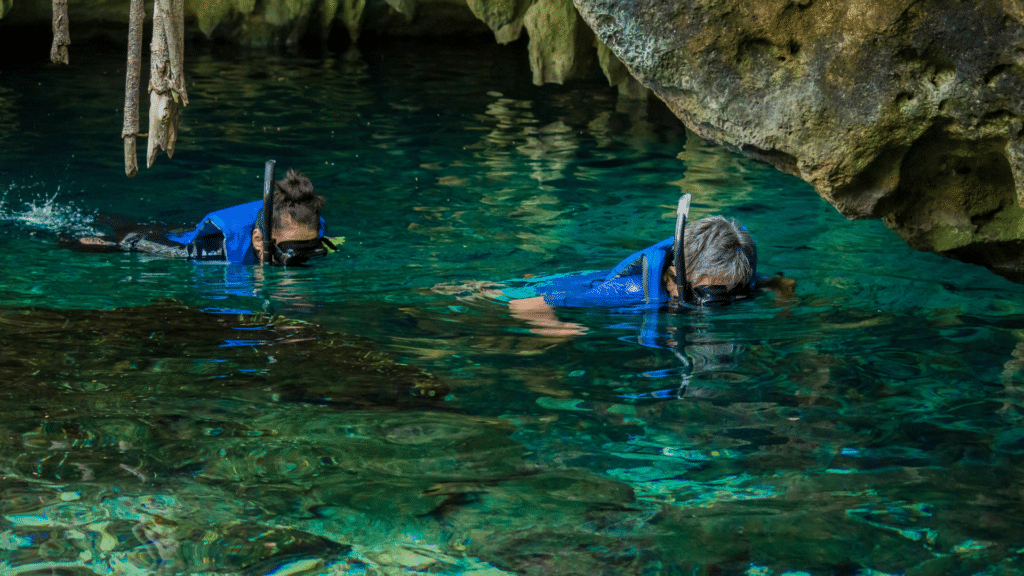 Two travelers snorkeling in clear cenote waters