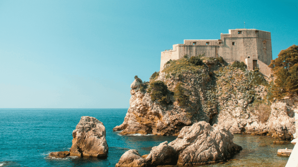 Historic stone fortress rising above rocky cliffs and the blue Adriatic Sea in Dubrovnik, Croatia